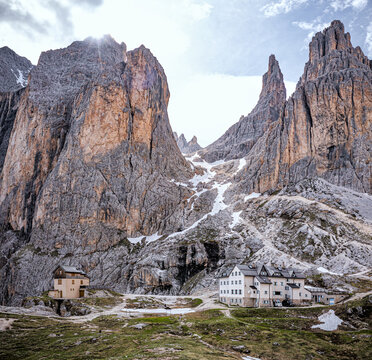 Aerial view of jagged peaks rise dramatically, their rocky faces kissed by lingering snow near Refugio Passo Principe, San Giovanni di Fassa, Trentino-South Tyrol, Italy.