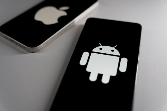 Smartphones displaying Apple and Android logos on black screens with focused view on Android operation system
