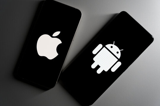 Two smartphones at an angle displaying Apple and Android logos on black screens.