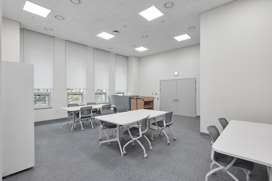Small clean office meeting room with white furniture and windows