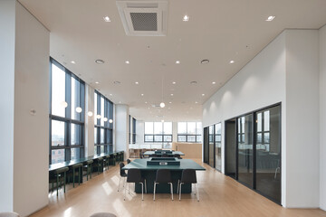 Modern open space library or study hall with green tables