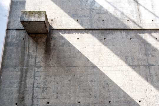 Industrial minimal architecture concrete wall with strong shadow and light revealing abstract geometry and textured surface detail