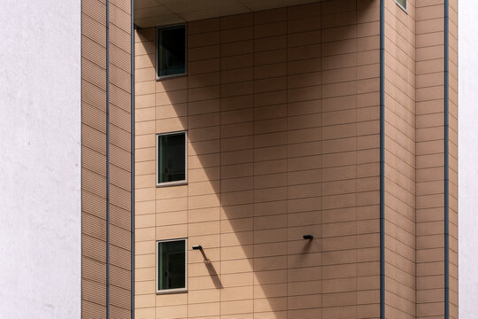 Modern minimal architecture building facade wall with window and strong shadow revealing geometry and texture in clean urban exterior