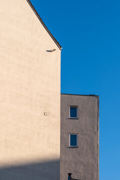 Modern minimal architecture building facade wall with window and strong shadow under sky creating urban geometry and clean composition