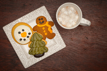 Winter Themed Cookies on a White Plate with a Cup of Hot Chocolate