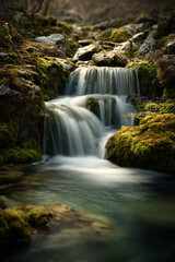 Fototapeta premium A waterfall photographed with a long exposure, creating silky motion blur in the flowing water.