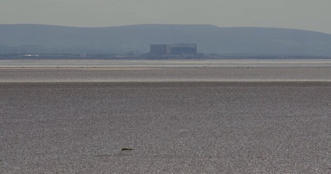 Long shot of Heysham Nuclear Power Station in Morecambe Bay at low tide on the A5057, Goads Barrow, near Ulverston