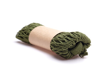 Olive string bag rolled neatly with a paper band, showcasing its eco-friendly design and versatility for shopping, beach trips, or daily errands, emphasizing sustainable living