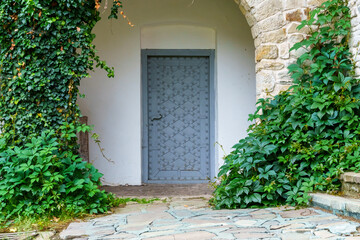 Naklejka premium close up of architectural details, old stone wall with arch and door