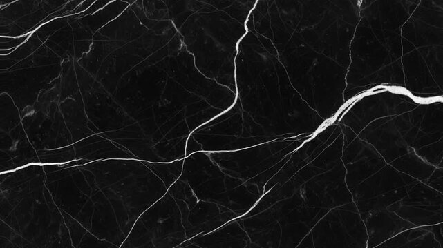 A close-up aerial view of a dark marble surface with intricate white veins, showcasing the natural pattern of the stone.