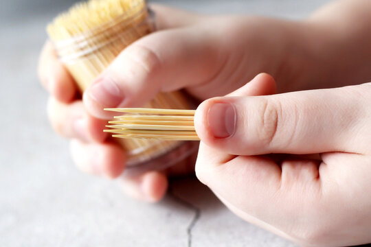 A jar of bamboo toothpicks in children's hands. Oral hygiene.
