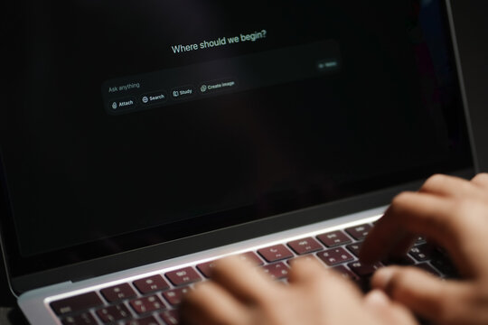 The hands of a man using a laptop or smartphone to operate artificial intelligence (AI), inputting commands and interacting with AI, AI assistants, chatbots, chat GPT.