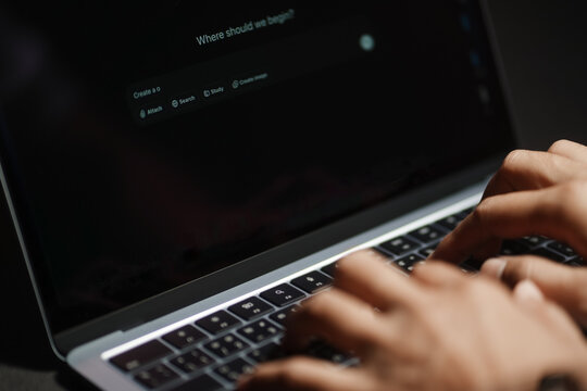 The hands of a man using a laptop or smartphone to operate artificial intelligence (AI), inputting commands and interacting with AI, AI assistants, chatbots, chat GPT.