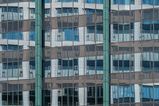 Modern urban architecture building facade with windows grid on highrise glass creating repetitive pattern for corporate realestate background