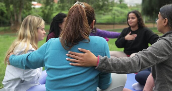 Women's circle during a group meditation with people of different age and body types - Healthy lifestyle, feelings and healing concept 