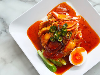 Top-down still of a saucy rice dish: Chinese BBQ pork, roasted pork, and Chinese sausage layered over steamed rice, draped in a glossy sweet sauce