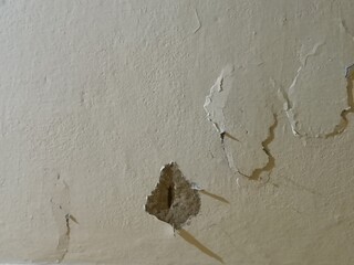 Macro Texture of Damaged Concrete Wall - Detailed View of Peeling Paint and Deep Pothole Chip on an Aged Weathered Plaster Surface