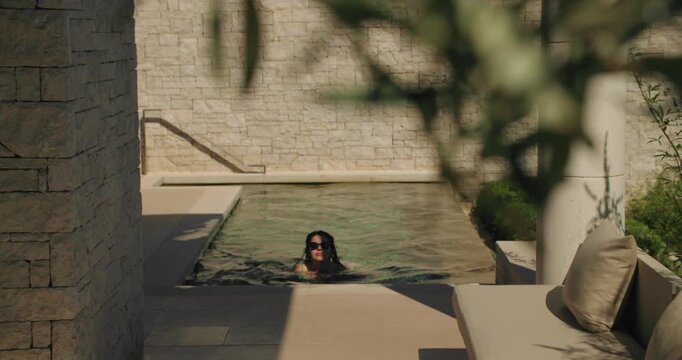 Woman swimming in luxury villa private pool
