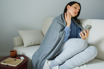 Obraz premium Woman on a sick leave at home having active conversation with medical worker through video mobile connection. Calling family doctor, online medicine, home treatment, telemedicine