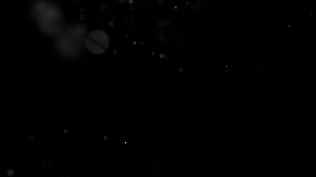 Tiny white air particles and micro-dust floating in a light beam.