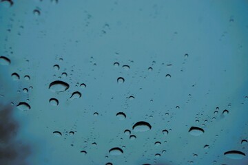 Abstraktes Motiv mit Wassertropfenmuster auf Glasscheibe vor blauem Himmel bei K&auml;lte und Frost im Winter als Hintergrund