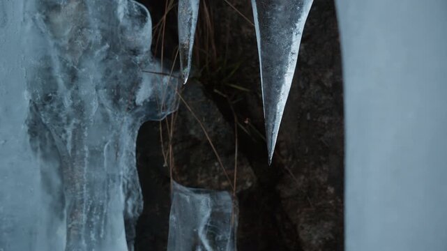 Close up of ice melting and water droplet drops down from the tip of the ice on a winter day in Norway