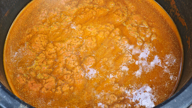 A traditional method of dyeing cotton yarn using a fermentation process with turmeric powder.