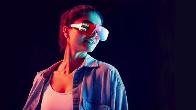 Woman wearing futuristic visor glasses with code reflection on dark background. Concept of digital future, technology vision, innovation mindset, cyber style, confidence and modern tech lifestyle.
