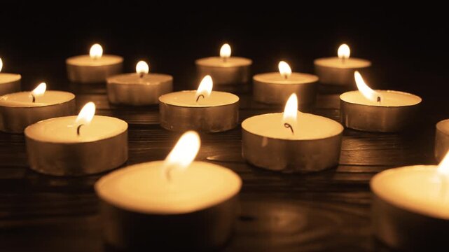 Many Burning candles set in darkness