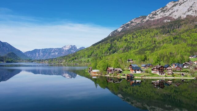 Aerial view of Altausseer See and village surrounded by mountains reflecting in calm alpine waters. Austria, Salzkammergut. Nature beauty in summer season