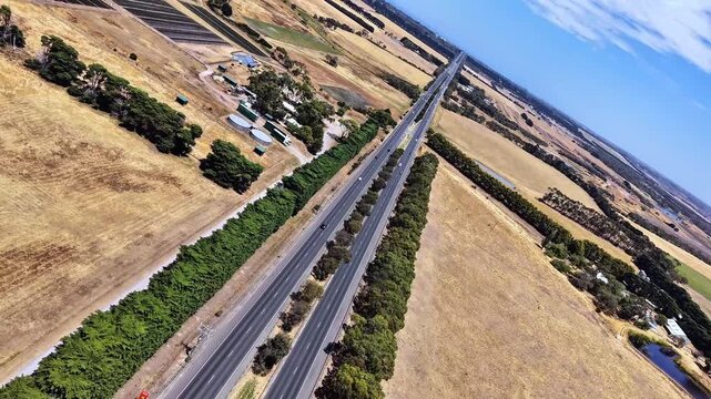 aerial top view of highway road through countryside landscape with moving vehicles