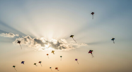 Obraz premium Colorful kites flying in the sky during sunset with clouds 