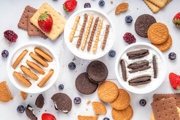 Obraz premium Set of different trendy yogurt and cookie dessert. Simple two ingredient japanese yogurt cheesecake, viral tasty quick recipe made with greek yogurt, various biscuits and berries