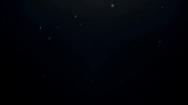 Opening golden flare sending particles drifting forward, thinning and fading across dark gradient