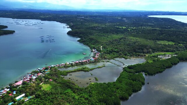 Cinematic slow side angle drone over Luan Island showcasing waves lapping the shore and tropical forests.