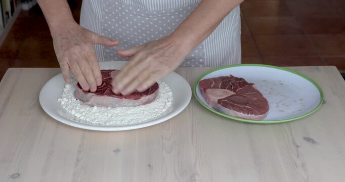 Flouring Veal Shanks for Traditional Italian Ossobuco Recipe.