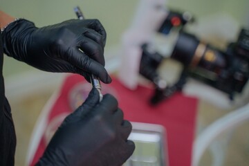 The dentist prepares anesthesia for administration to the patient. Painkiller for the patient. Medicine in a syringe. The doctor's gloved hands are holding a syringe with the drug.