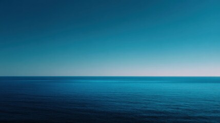 Obraz premium Photograph of the ocean. the sky is a deep blue color and the water is a lighter shade of blue. the horizon line is visible in the distance, and the horizon appears to be slightly blurred.