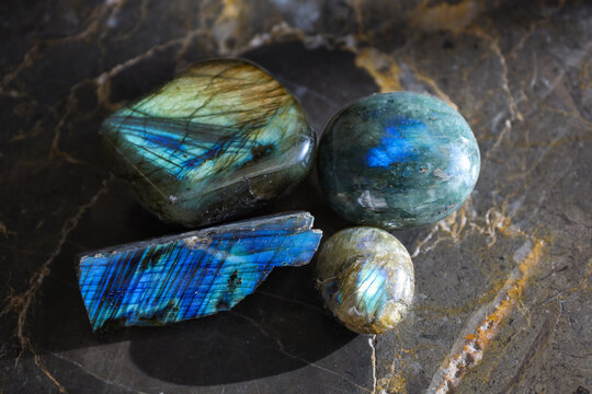 Blue-Green Labradorite Gemstones on Dark Stone Surface
