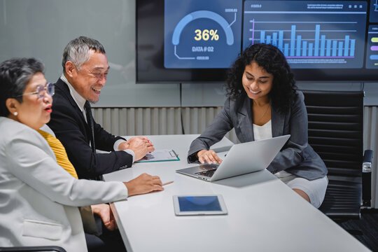 Diverse business team analyzing financial data and performance metrics during a corporate meeting. Professional teamwork, strategy planning, and data-driven decision making in modern office.