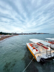 Fototapeta premium Small motorboat docked near beach under dramatic cloudy sky