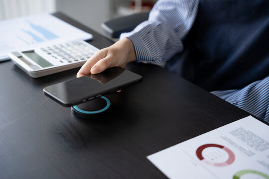 Woman charging smartphone by using magnetic wireless charger