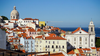 Obraz premium A picturesque European cityscape with white buildings and red roofs by the ocean