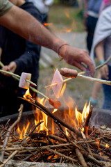 Fototapeta premium Children and boy scouts roasting marshmallows and sausages over a bonfire. Scout activity.