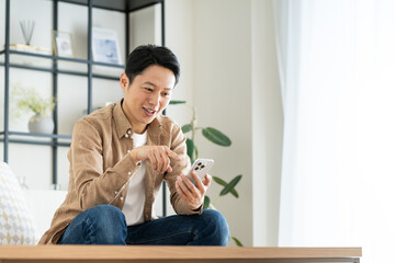 リビングでスマホを使うミドルの男性