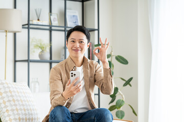 リビングでスマホを使うミドルの男性