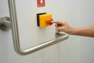 Asian elderly woman press emergency button in toilet.