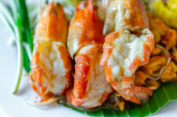 Prawn Pad Thai, close-up. Pad Thai with grilled river prawns, stir fried noodles in rich sauce served with fresh vegetables. Authentic Thai cuisine, ideal for food, restaurant, and travel content