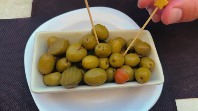 Juicy green olives on a table at a street cafe terrace. Tapas an appetizer before the main course. 