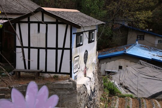 JEONJU, SOUTH KOREA - APRIL 4, 2023: Public space view in Jaman Mural Village in Jeonju city. The dog-painted house is the mural "I Love You, Jaman Village" by Lee Young-sik, Korean artist.